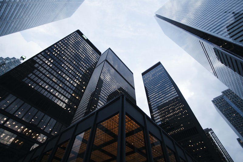 Modern corporate skyscraper looking up to the sky, glass reflection, golden hour sunlight, architectural photography, 8k